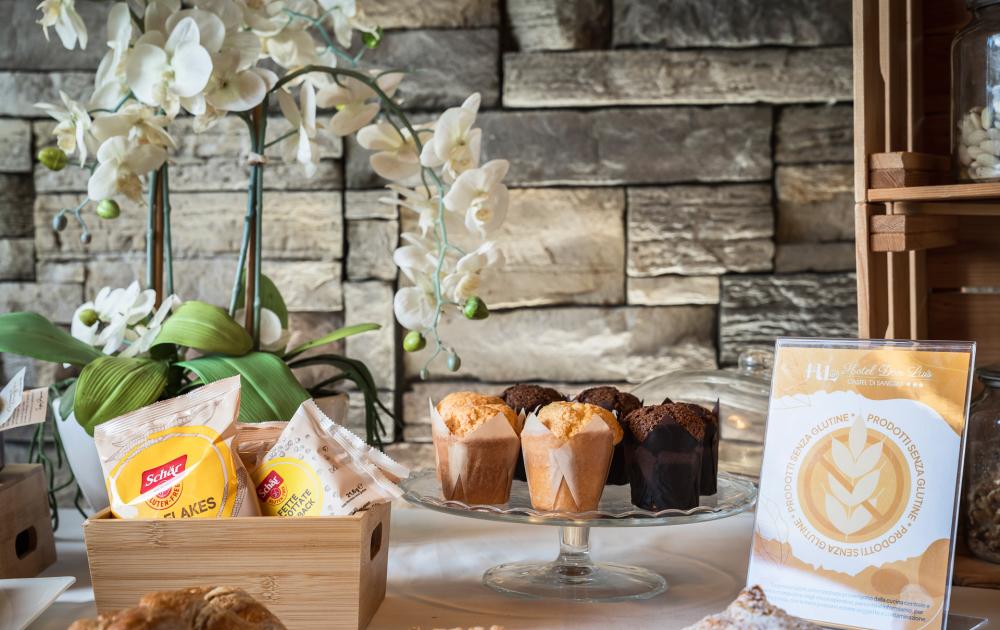 Gluten-free breakfast with muffins, cereals, and decorative flowers.